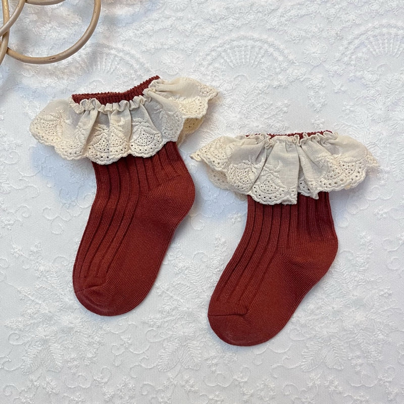 Soft green lace socks with frilly edges and a small white flower, sweet toddler apparel