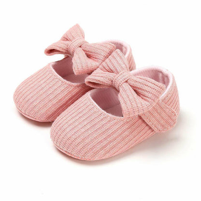 Close-up of girls' first walker shoes with cute bow detail, perfect for baby fashion.