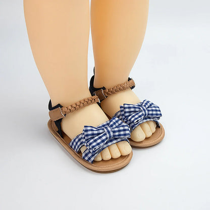 Baby girl's pink sandals with a prominent princess bow, ideal for summer outfits.