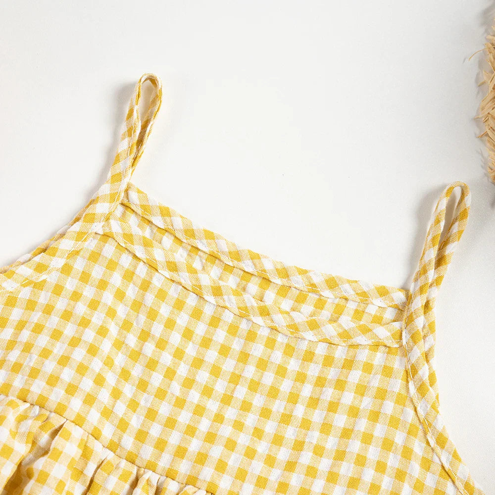Cute toddler girl in a soft plaid cotton romper dress, showcasing baby clothing comfort