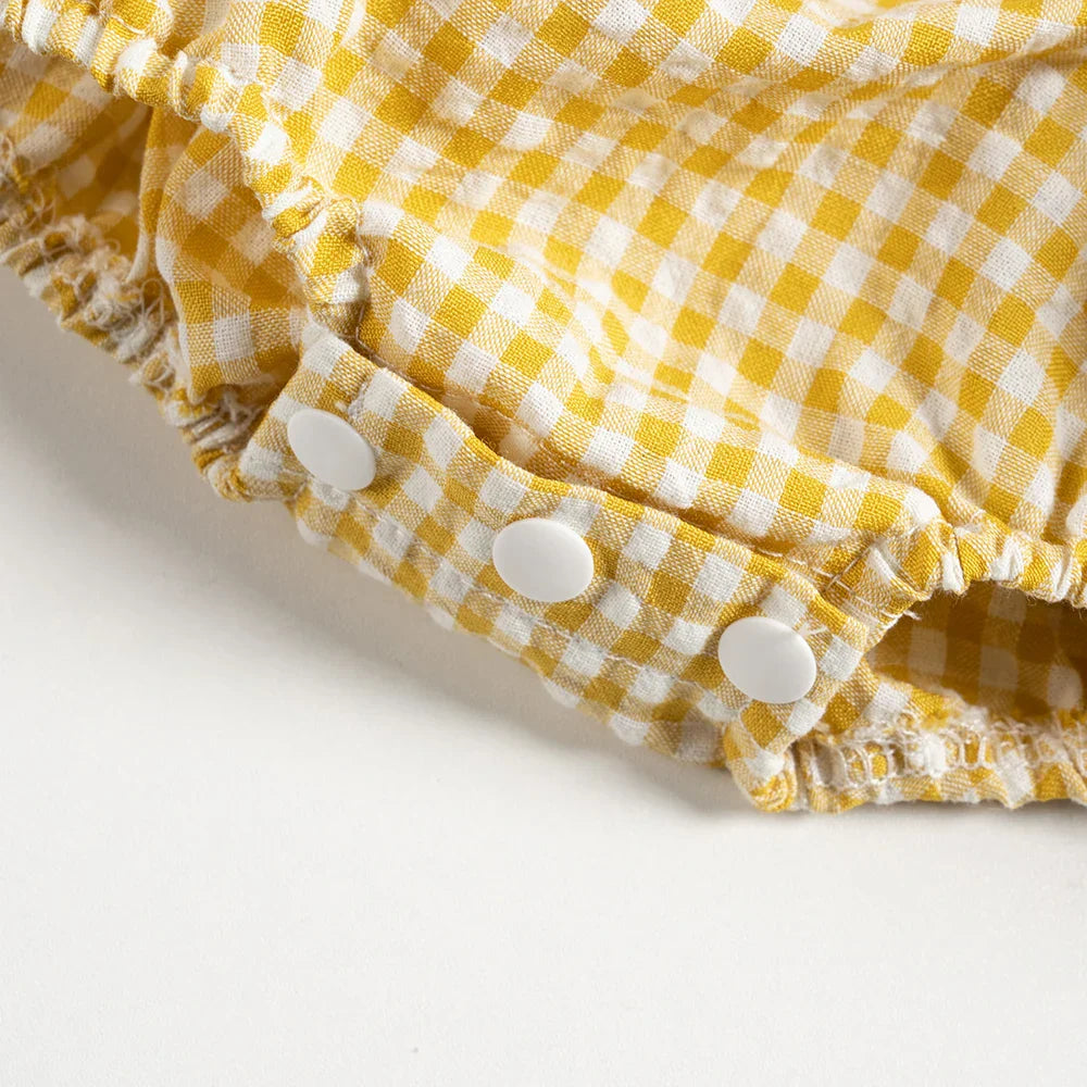 Back view of a girls' plaid cotton romper dress, demonstrating easy care design for toddlers