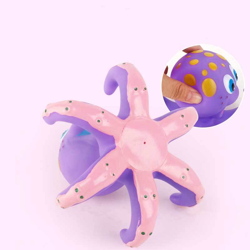 Baby reaching for the BPA free octopus bath ring toss game in a tub