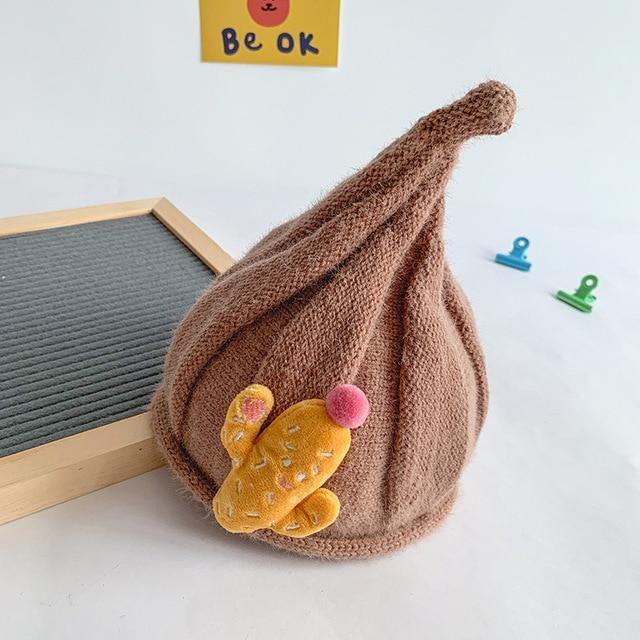A child playing outdoors wearing a warm knit gnome beanie, essential winter clothing for kids.
