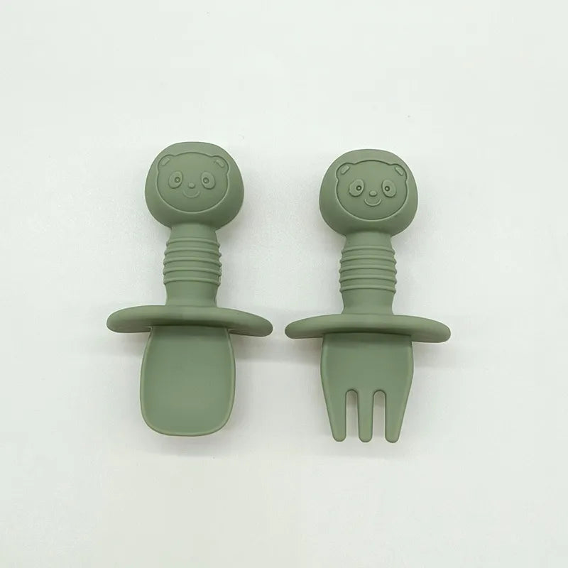 Child grasping the silicone bear baby fork, demonstrating the design for easy handling