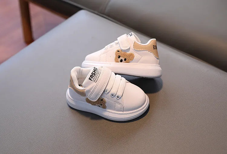 Stylish kids' flats with bear motif, black with white details, secure hook-and-loop fastening.