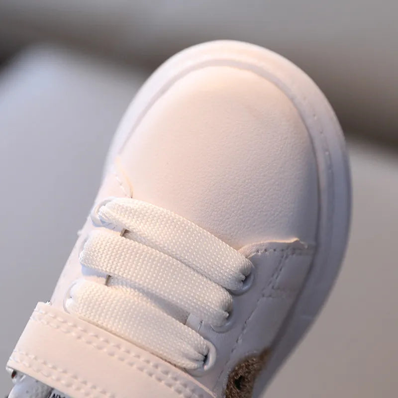 Close-up of a toddler bear sneaker, showing soft material and detailed bear ear and face design.
