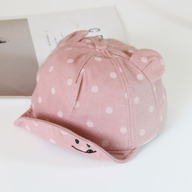 Breathable cotton polka dot sun hat for babies, designed for comfortable infant headwear and child safety.