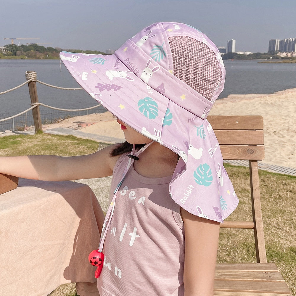 Infant wearing a soft, wide-brim sun hat with ties, ensuring comfortable UV protection for delicate skin