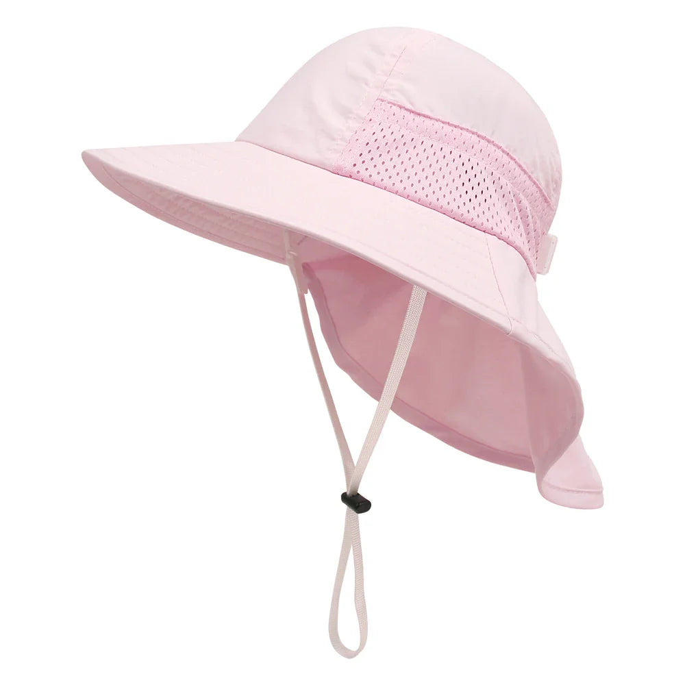 Happy child in a vibrant orange adjustable sun protection bucket hat, confidently exploring a park environment.