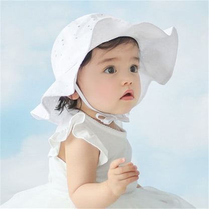 Close-up of a pink kids' adjustable cotton sun hat featuring a wide brim for maximum sun protection.
