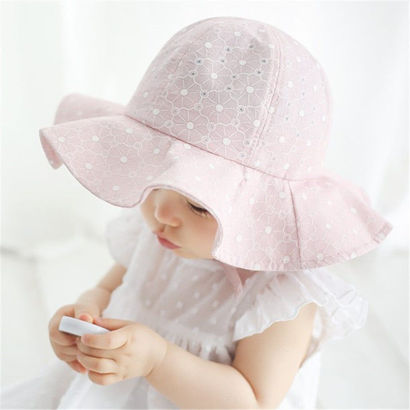 Green baby accessory sun hat, lightweight cotton with a secure adjustable fit, great for park trips.