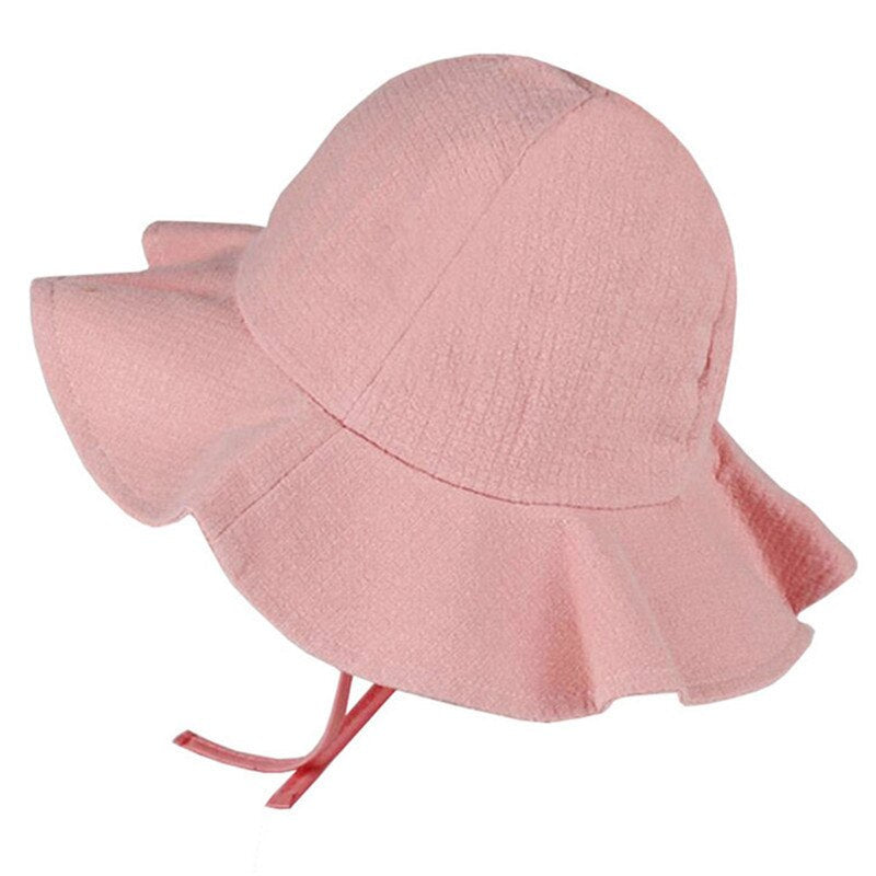 Side view of a child's adjustable cotton sun hat in white, protecting face and neck from summer sun.