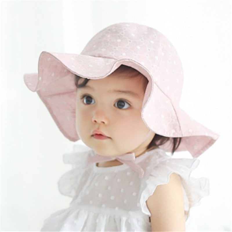 Cute infant in a white adjustable cotton sun hat, ready for a sunny day's adventures.