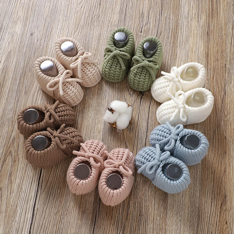 Baby wearing white knitted booties, comfortable infant footwear for little feet, newborn shoes