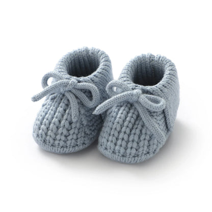Assortment of colorful knitted baby booties, soft handmade crib shoes in various shades, baby shower gift idea