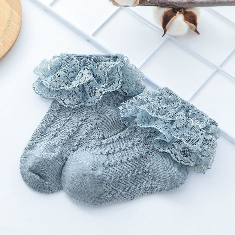Baby girl wearing white lace ruffle ankle socks with Mary Jane shoes