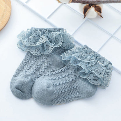 Baby girl wearing white lace ruffle ankle socks with Mary Jane shoes