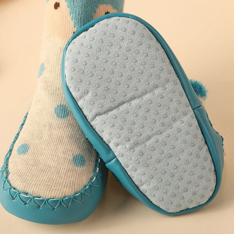 Anti-slip baby socks in various animal designs laid flat, showcasing their vibrant colors and soft fabric.