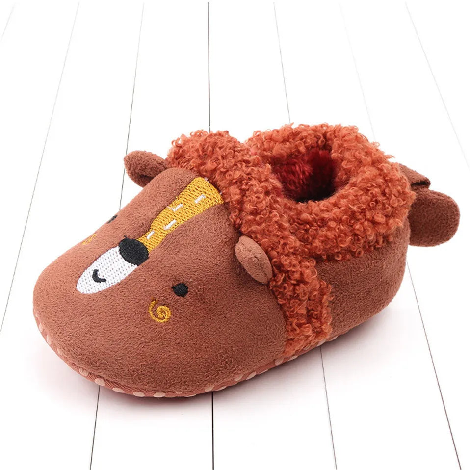 Top view of a baby's feet wearing cozy non-slip animal slippers.