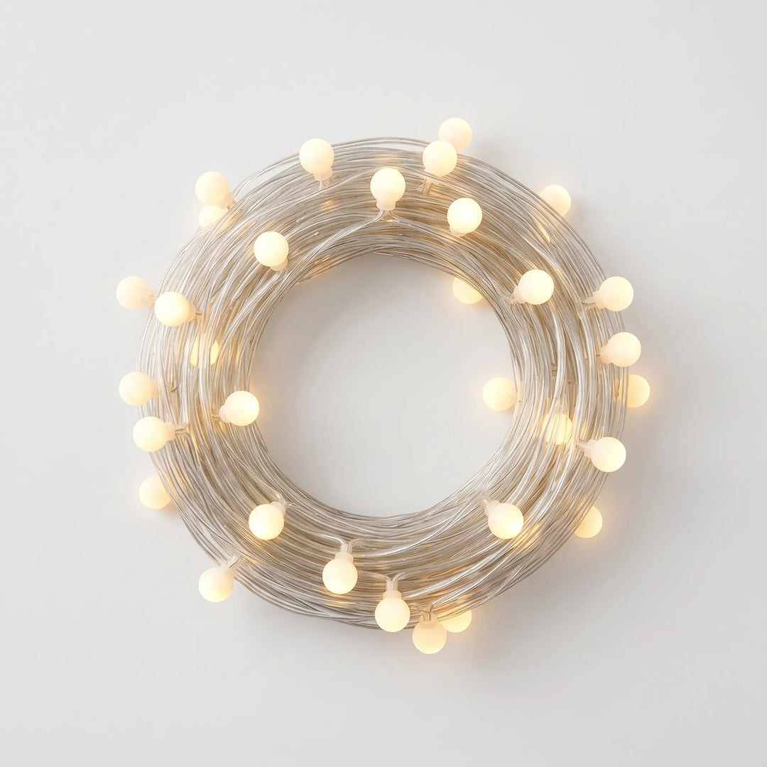 Warm Globe LED string lights illuminating an outdoor patio, creating an inviting ambient atmosphere for entertaining.