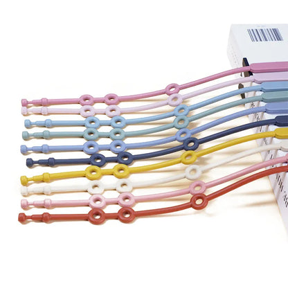 Green adjustable silicone toy strap tethering a teething toy to a stroller bar for infants.