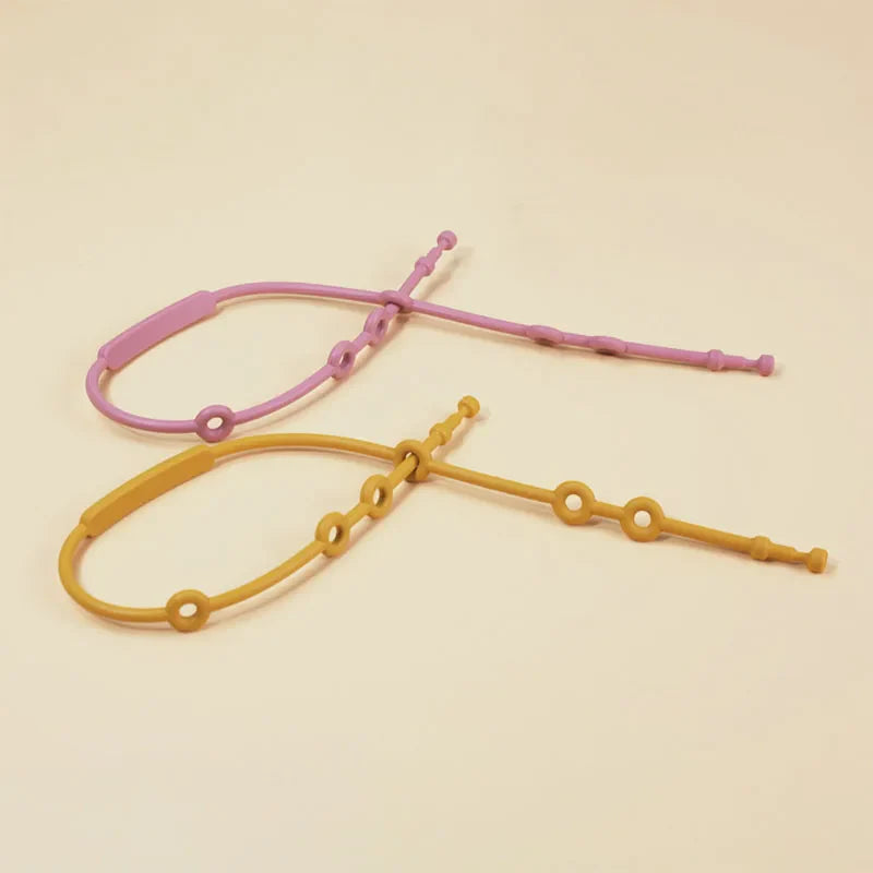 Set of colorful baby adjustable silicone toy straps in blue, pink, and green, showing versatility.