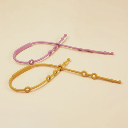 Set of colorful baby adjustable silicone toy straps in blue, pink, and green, showing versatility.