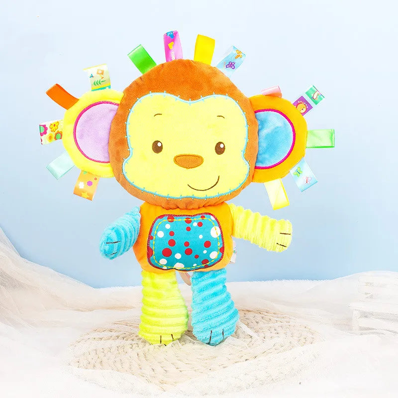 Baby's hand touching a soft sensory plush toy with rattles and bells, stimulating touch