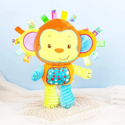 Baby's hand touching a soft sensory plush toy with rattles and bells, stimulating touch