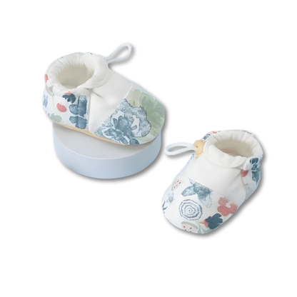 Soft sole baby booties in a neutral color, showcasing a cozy design for infants.