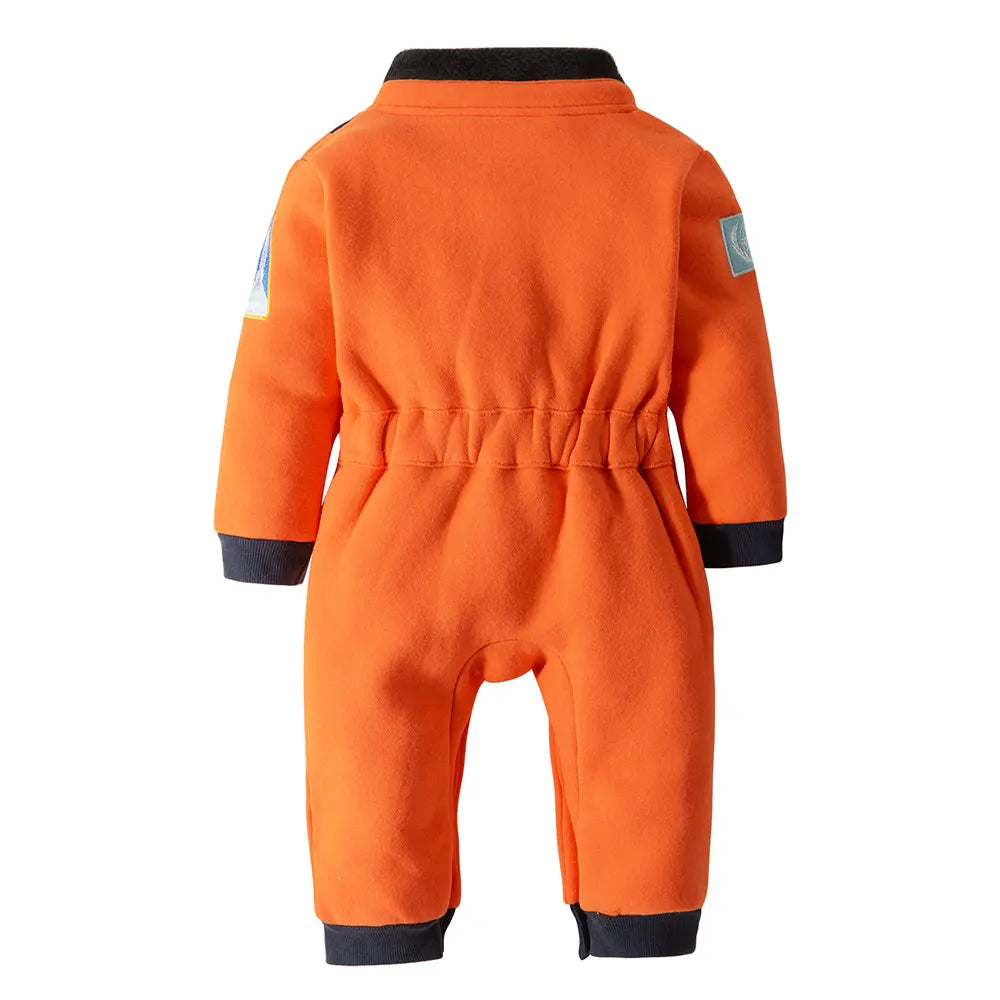 Close-up of baby astronaut romper's embroidered patches, including a rocket and planet