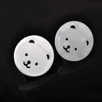Stack of 10 white baby bear socket covers, emphasizing their child safety and electrical protection role.