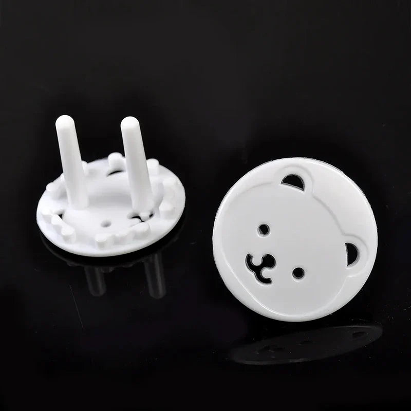 Child safety plug protectors, white bear design, shown on an electrical outlet for baby proofing.