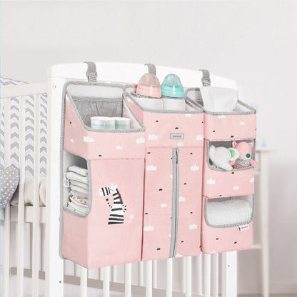 Crib organizer caddy with multiple pockets, perfect for baby essentials, hanging on wooden crib rail