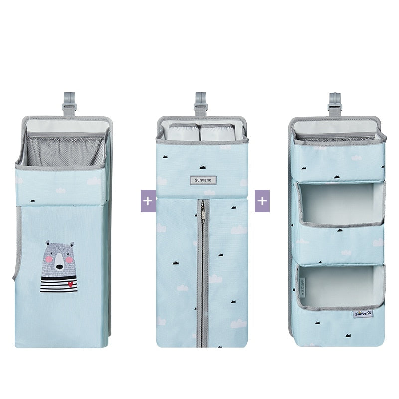 Hanging diaper and wiped caddy for baby crib, shown with pacifiers and small toys in pockets