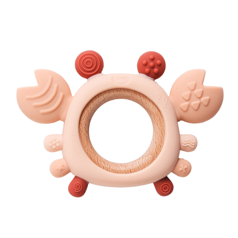 Close-up of a pink silicone crab baby teether with beech wood ring, designed for newborn gum relief