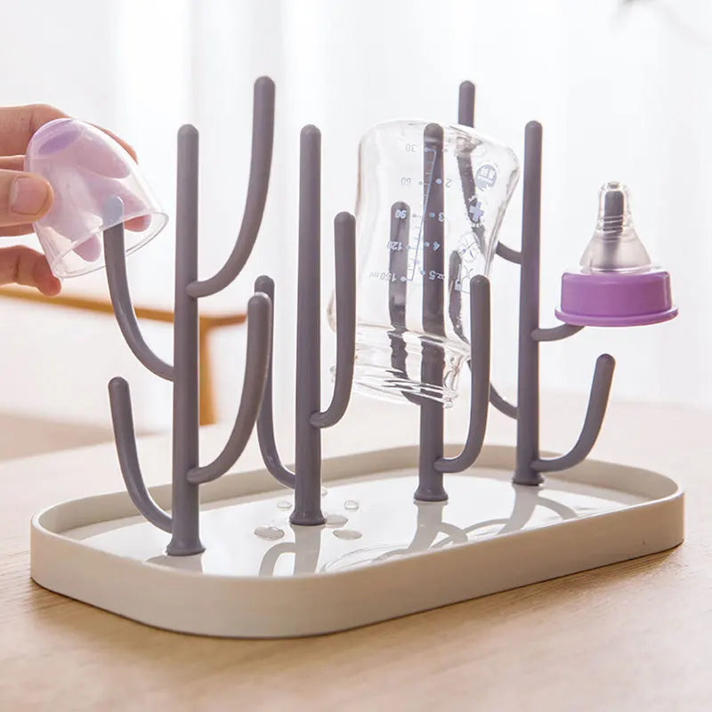 Baby bottle drying rack with removable drainer tray, holding several bottles & nipples organized for hygiene