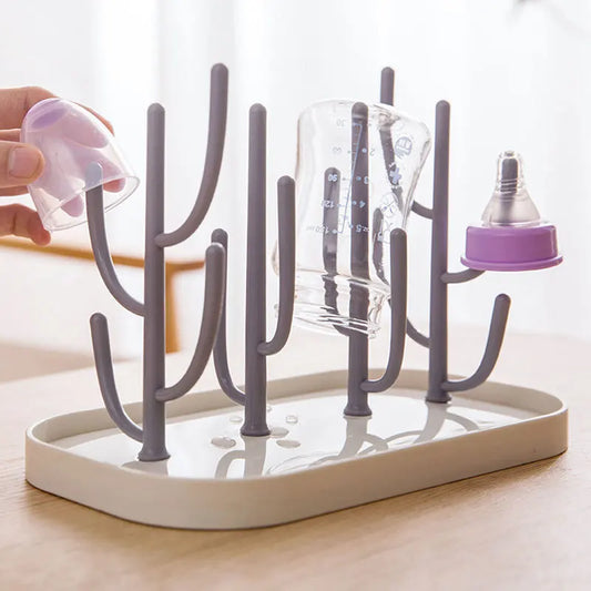 Baby bottle drying rack with removable drainer tray, holding several bottles & nipples organized for hygiene