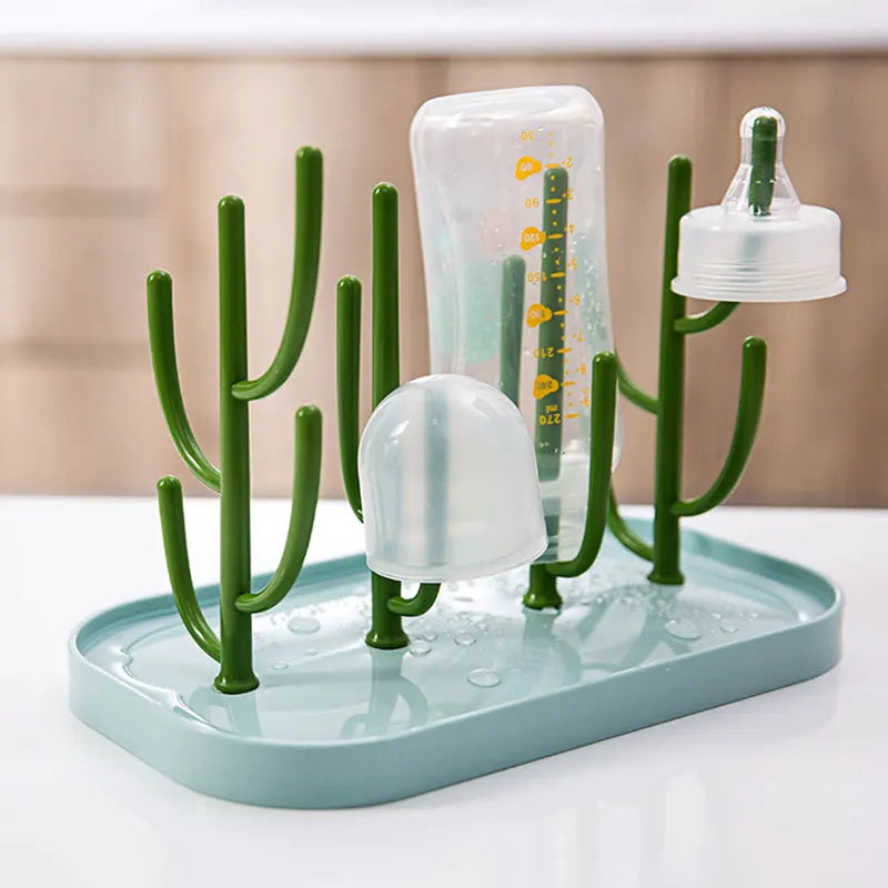 Space-saving baby bottle dryer with a white base and green drying pegs, keeping feeding essentials tidy