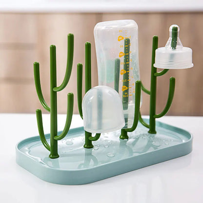 Space-saving baby bottle dryer with a white base and green drying pegs, keeping feeding essentials tidy
