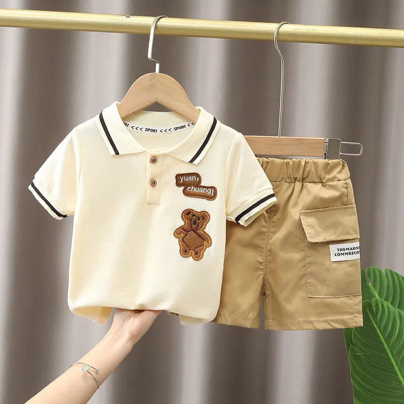Adorable baby boy outfit featuring a graphic cartoon tee and solid color summer shorts.