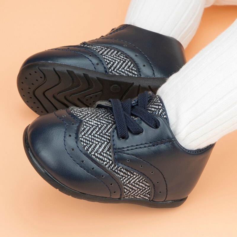 Baby boy footwear: soft sole leather first walker shoes, adorned with a stylish Aztec print, ideal for infants.