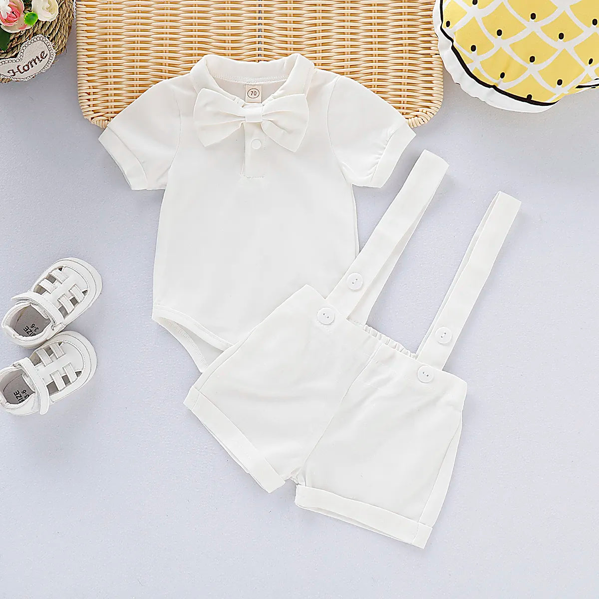Stylish baby boy gentleman romper in a breathable cotton blend, featuring a charming bow tie and suspenders