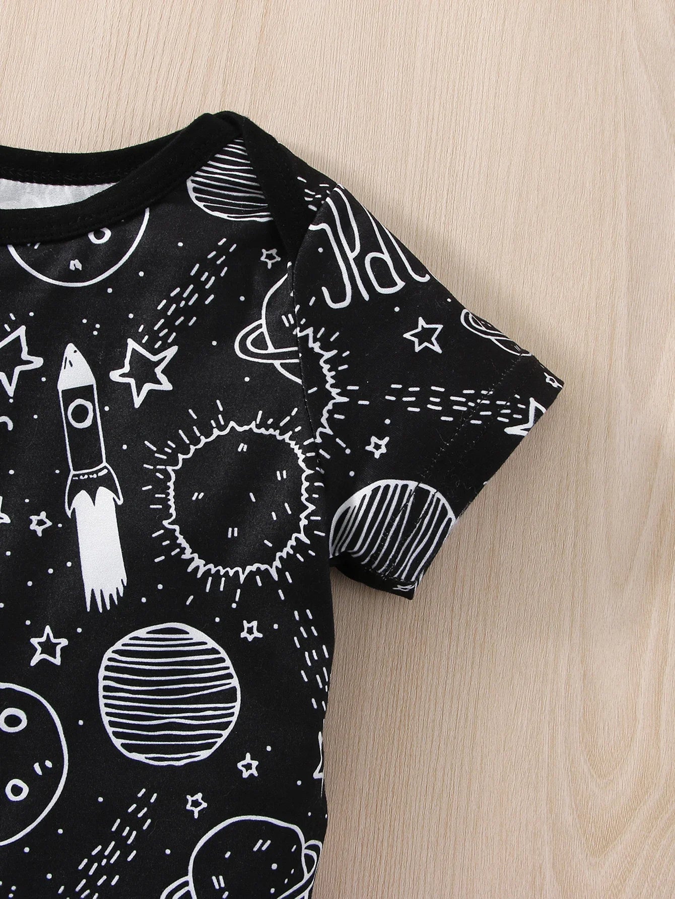 Infant baby boy wearing blue astronaut romper, happy, crawling on a soft rug