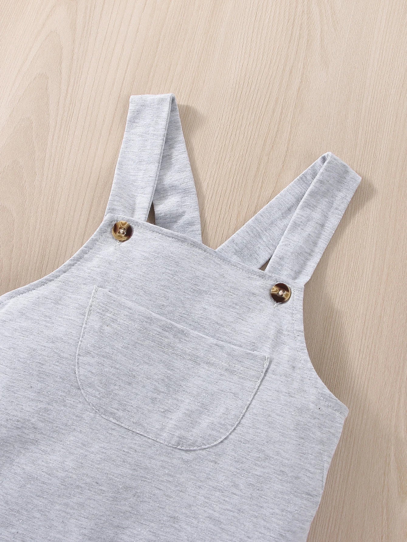 Flat lay of baby boy space outfit: blue astronaut romper, hat, and socks, newborn essentials