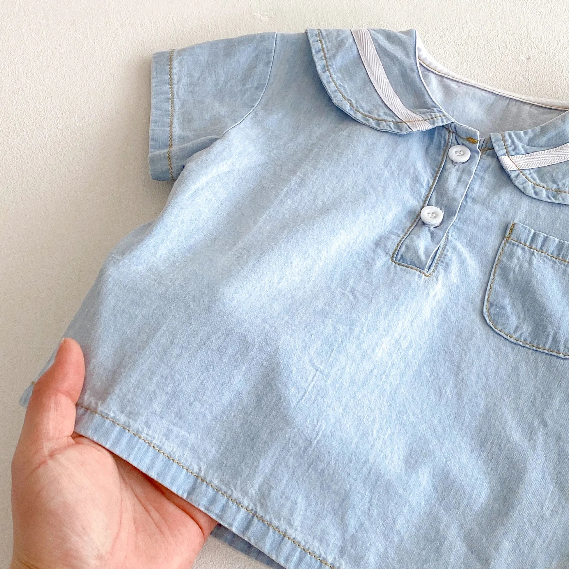 Detailed view of elastic waist shorts from baby boy's denim set, comfortable fit, kids fashion