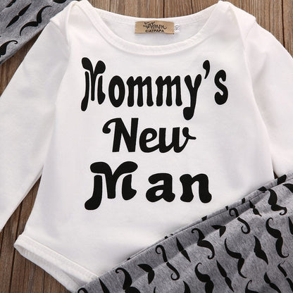 Full view of baby boy fashion 3-piece set: 'Mommy's New Man' white romper, black and white striped pants, hat