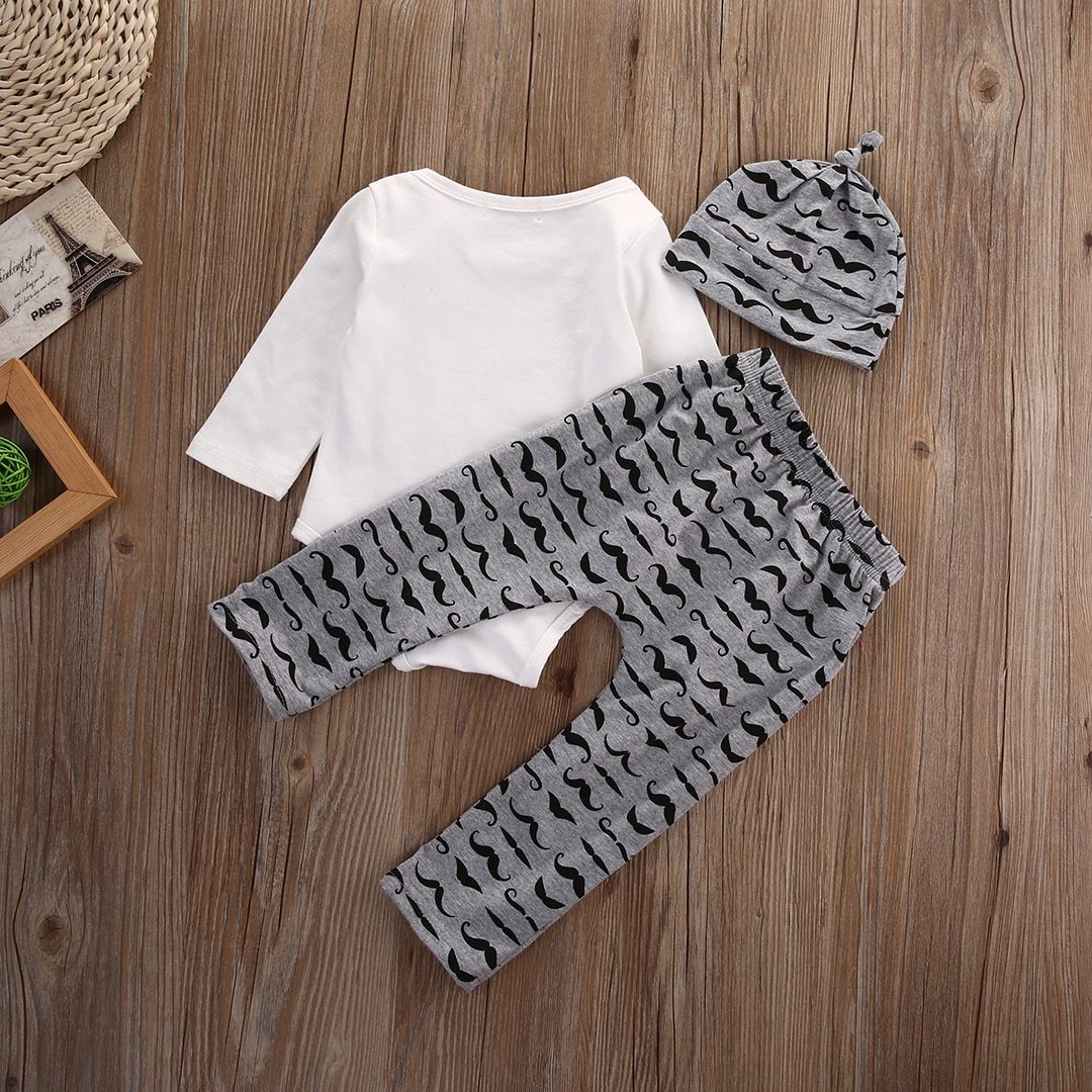 Baby boy outfit display showing a 'Mommy's New Man' bodysuit, striped trousers, and an adorable baby hat