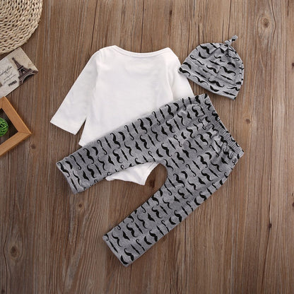 Baby boy outfit display showing a 'Mommy's New Man' bodysuit, striped trousers, and an adorable baby hat