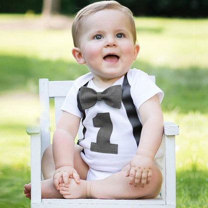 Baby boy's 1st birthday bow tie romper with suspenders, perfect for a smash cake photoshoot.
